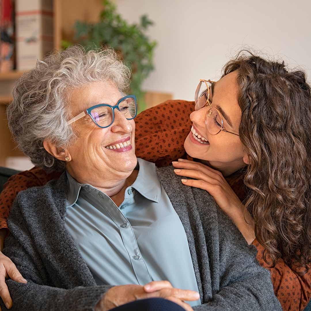 Younger woman laughing with older mother
